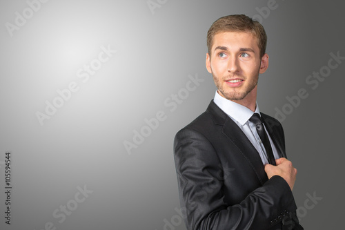 Young handsome businessman adjusting his tie