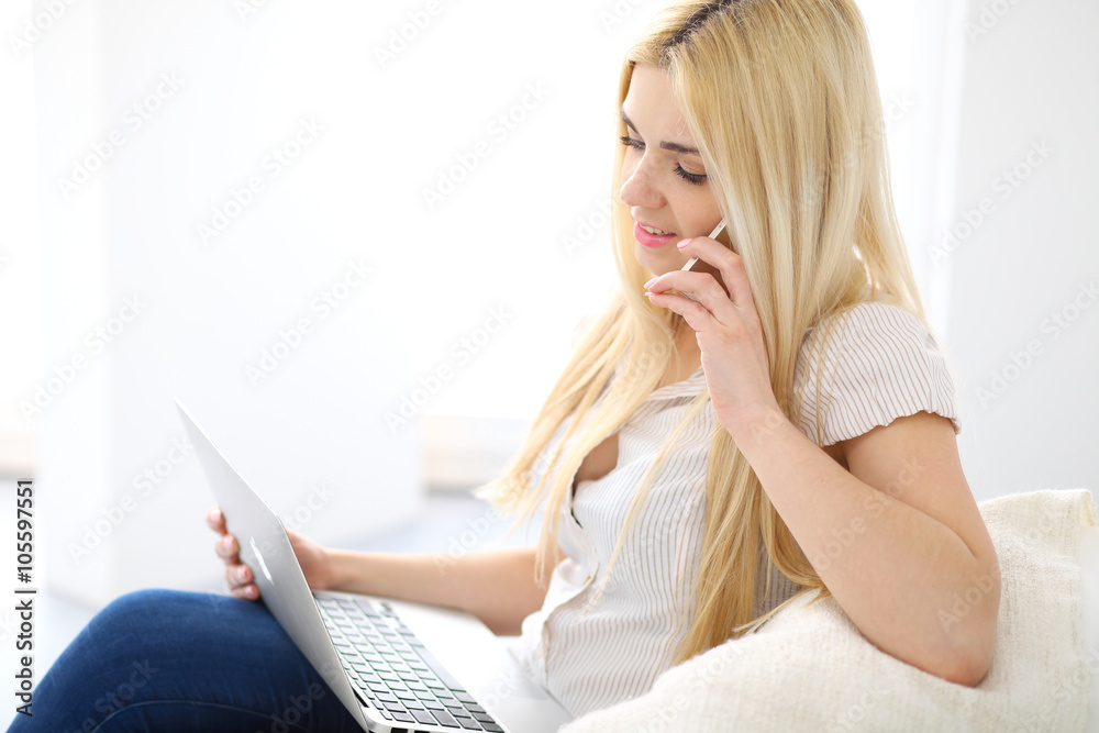 Happy woman doing online shopping at home . Close- up of a hand holding a credit card next to a laptop Happy woman doing online shopping at home . Close- up of a hand holding a credit card next to a laptop