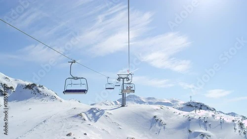 Riding the ski lift in sunny ski resort