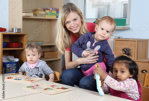 Erzieherin am Tisch mit Kinder beim Puzzeln
