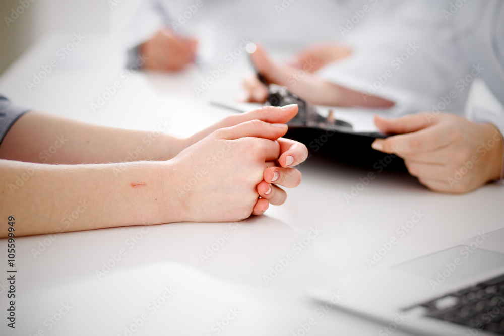 Doctor and patient are discussing something, just hands at the table Doctor and patient are discussing something, just hands at the table