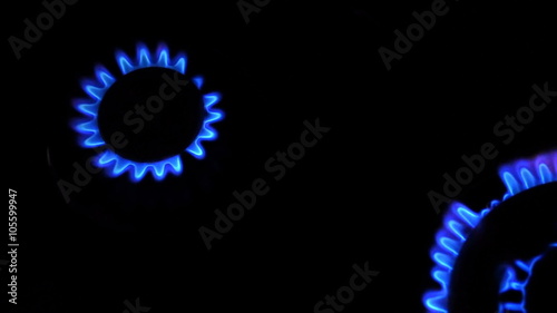 Two gas burners inflammation from kitchen stove, dark shot