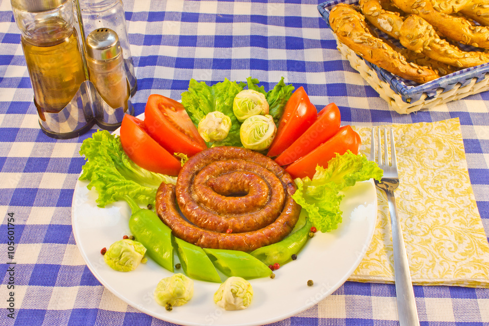 Sausages fried twisted into the spiral with vegetables Sausages fried twisted into the spiral with vegetables