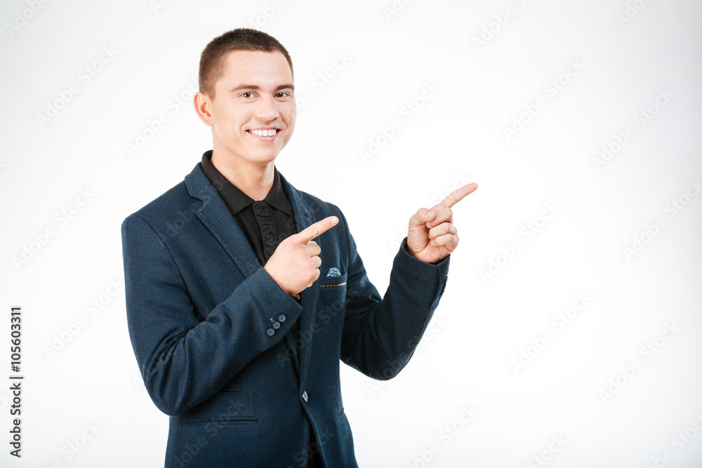Smiling businessman pointing finger away
