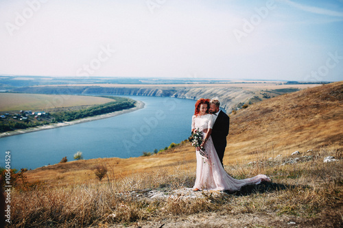 Groom is tenderly embracing  his bride