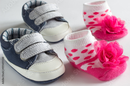 Shoes for the little boy and pink socks for girls. White backgro