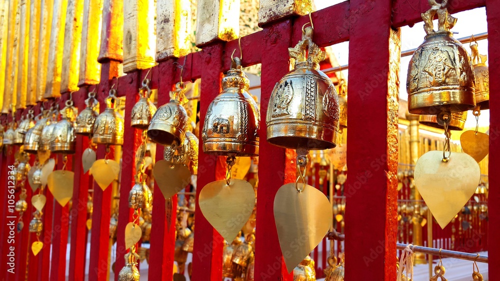 Buddhist brass bell  hanging on red fence in thai temple