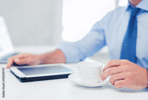 businessman with tablet pc and coffee in office