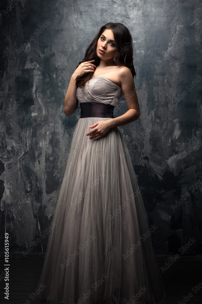 Fashion beauty portrait of gorgeous young woman with long curly hair in luxury evening dress Fashion beauty portrait of gorgeous young woman with long curly hair in luxury evening dress