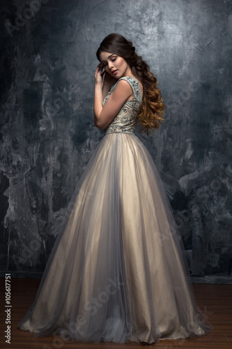 Fashion beauty portrait of gorgeous young woman with long curly hair in luxury e Fototapet