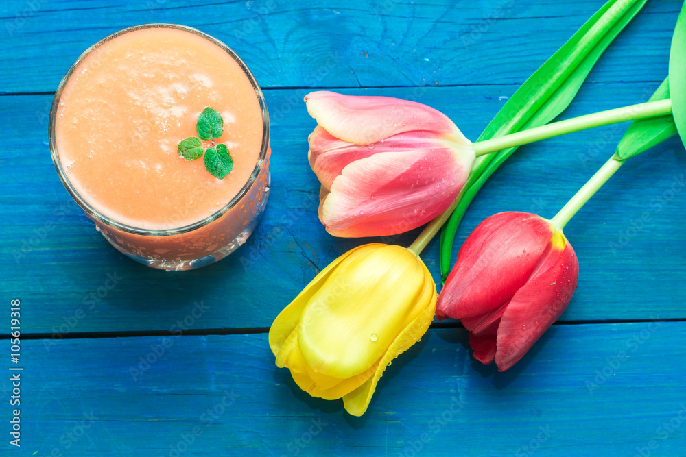 glass of fruit smoothies, and nearby are the tulips glass of fruit smoothies, and nearby are the tulips