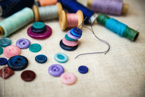 Sewing buttons and spools of threads on canvas