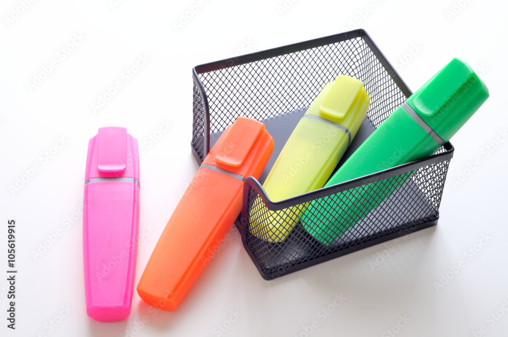 portaoggetti da ufficio e quattro evidenziatori colorati, su una scrivania  bianca Stock Photo