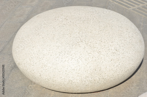 Big white round polished pebble on brick floor