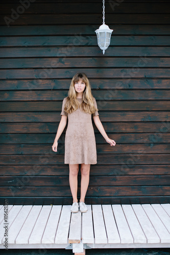 beautiful girl posing on a background of a wooden wall