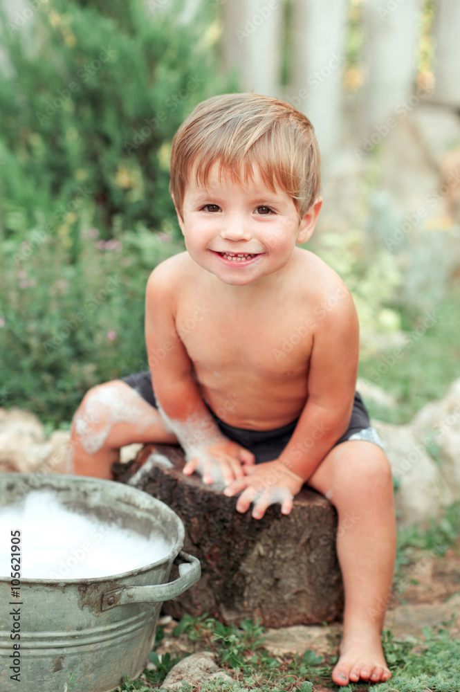 Smiling baby boy having bath outdoors. Looking at camera. Playing. Smiling baby boy having bath outdoors. Looking at camera. Playing.