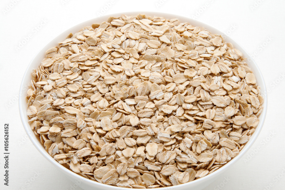 Oat flakes in a bowl. Oatmeal day.