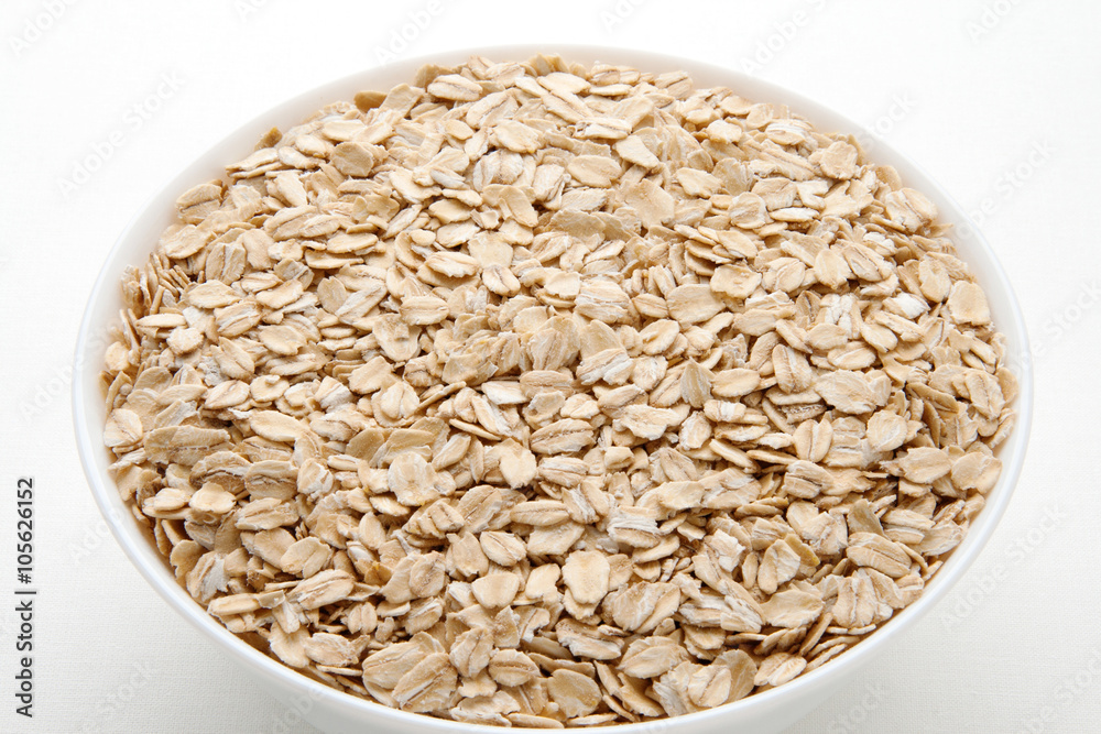 Oat flakes in a bowl. Oatmeal day. Oat flakes in a bowl. Oatmeal day.