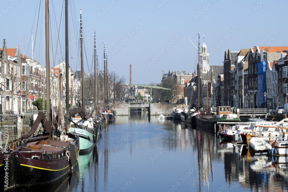 A skyline of vintage buildings and masts of ships in the old district of Delfshaven in Rotterdam, Netherlands.