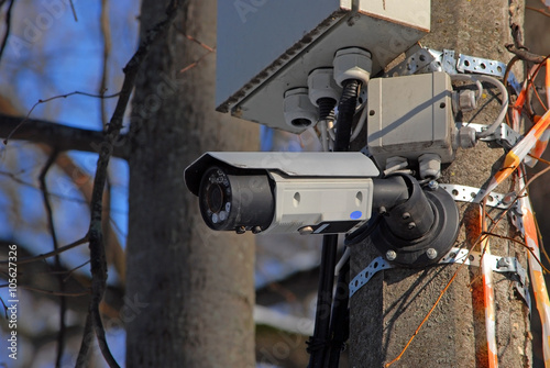Камера видеонаблюдения на столбе в городском парке