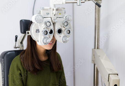 Woman checking on her eye with optometry machine