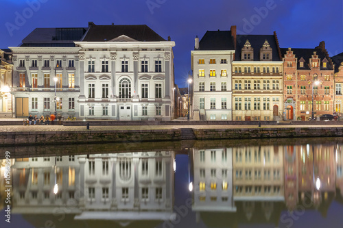 Picturesque medieval building on the quay Korenlei with reflections in Ghent town at night, Belgium