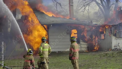 Camera pans to the right showing a house burning 
