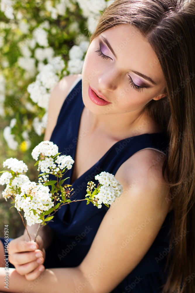Pretty smiling teen girl with white flowers ourdoors