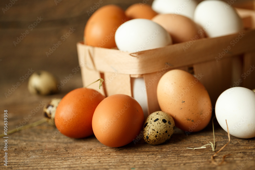 Chicken and quail eggs on a wooden rustic background Chicken and quail eggs on a wooden rustic background