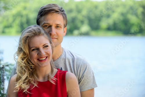 Young happy couple hugging and laughing on river background