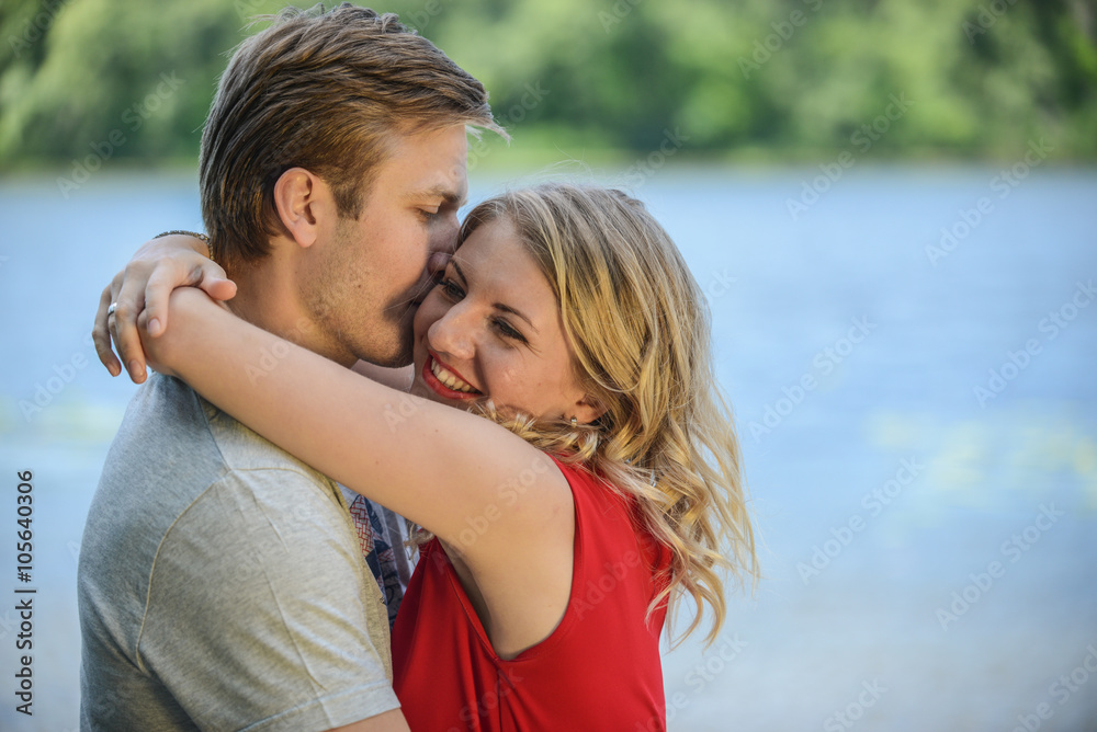 Young happy couple hugging and laughing on river background Young happy couple hugging and laughing on river background