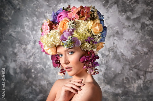 Young woman with luxuriant wig made of flowers