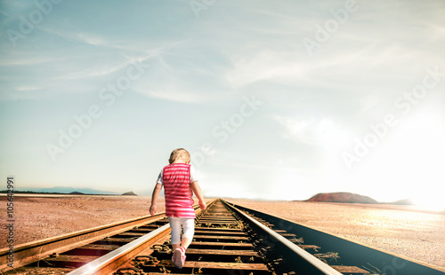 Kleines Kind in der Wüste auf den Schienen 