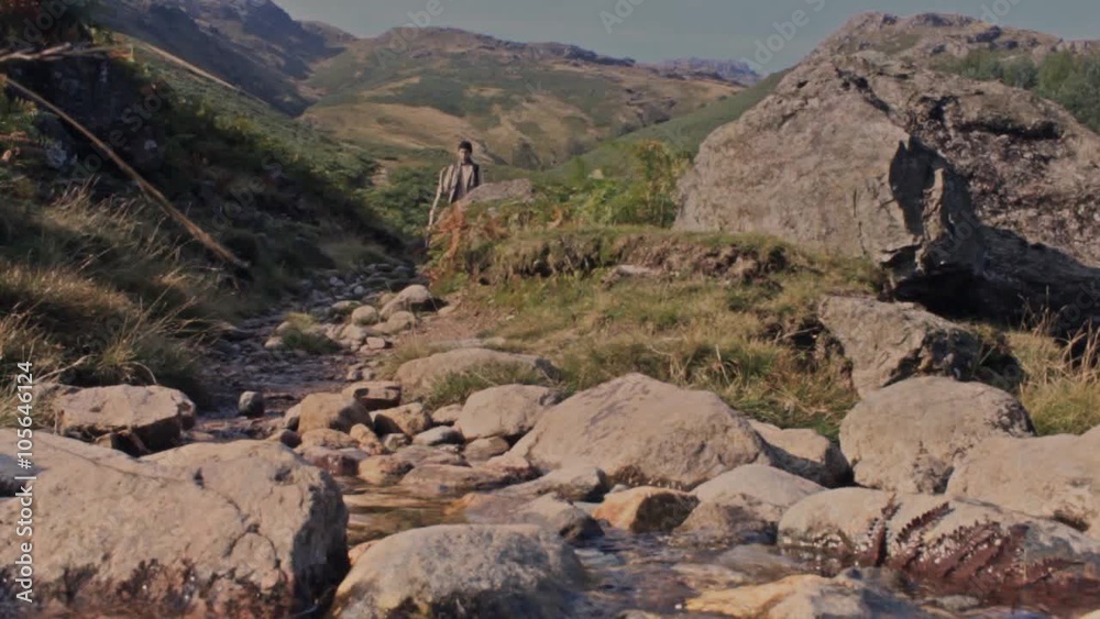Man walks mountain trail toward camera slow motion Man walks mountain trail toward camera slow motion