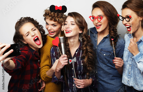 beautiful stylish hipster  girls singing karaoke 