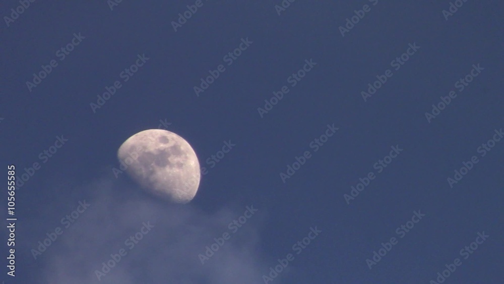 half moon in evening sky with passing clouds half moon in evening sky with passing clouds