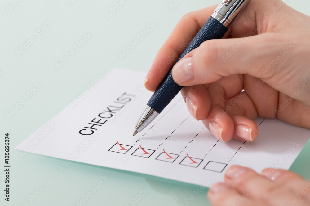 Woman Marking On Checklist Form With Red Pen Woman Marking On Checklist Form With Red Pen