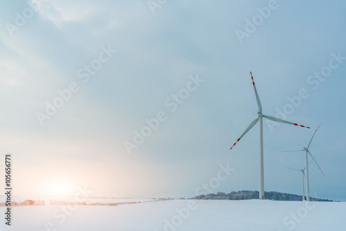 Sunset above windmill on the field in winter