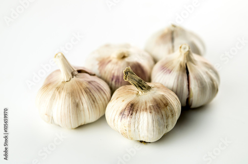 Group of unpeeled whole garlic heads isolated on white