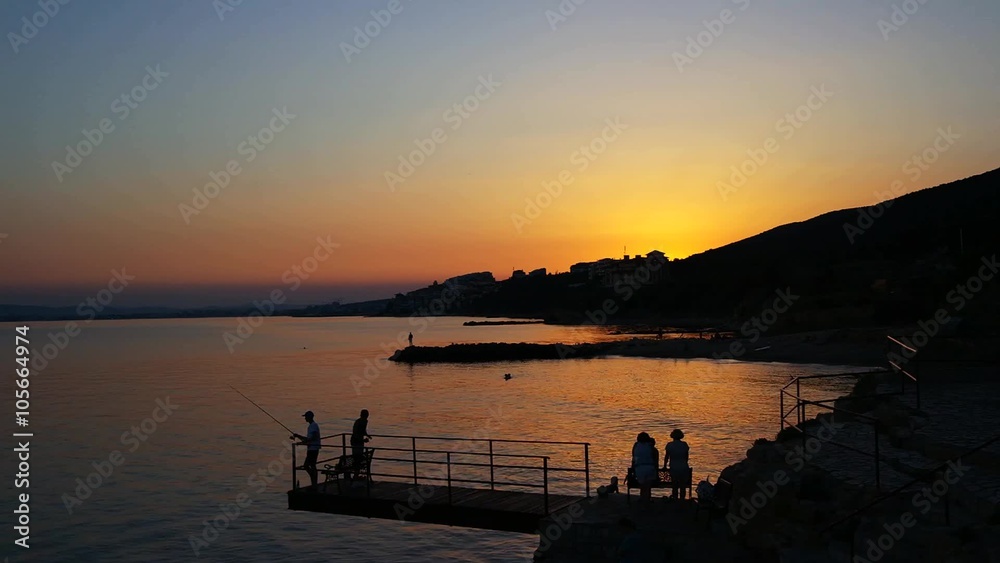 Sunset Over the Sea With Fishermans on the Pier Sunset Over the Sea With Fishermans on the Pier