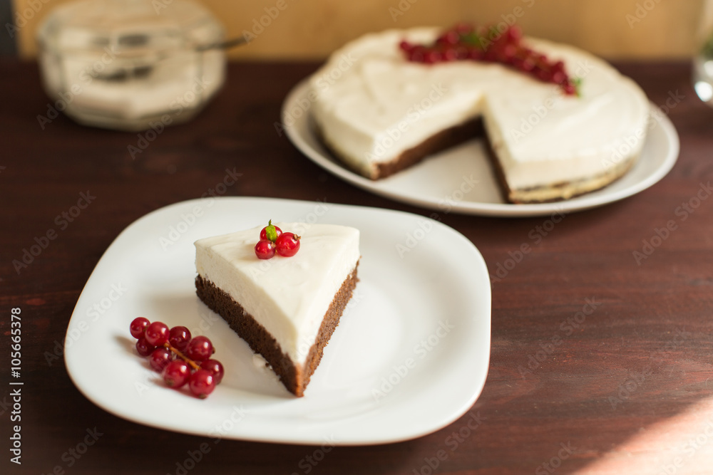 yoghurt cheesecake with fresh red currants on wooden table yoghurt cheesecake with fresh red currants on wooden table