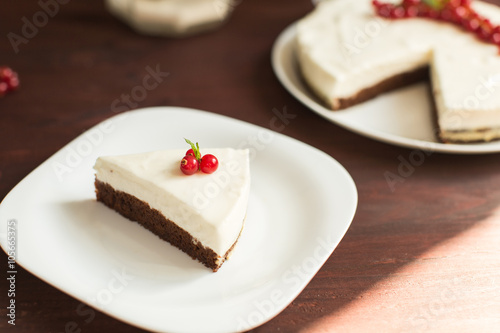 yoghurt cheesecake with fresh red currants on wooden table