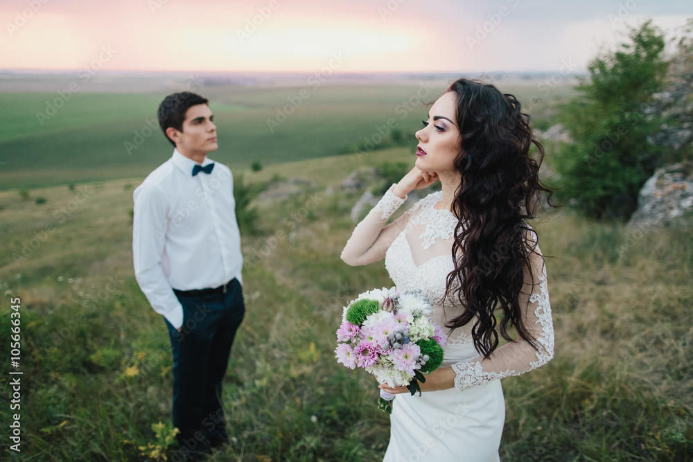 Beautiful wedding couple with bouquet flowers on the sunset Beautiful wedding couple with bouquet flowers on the sunset