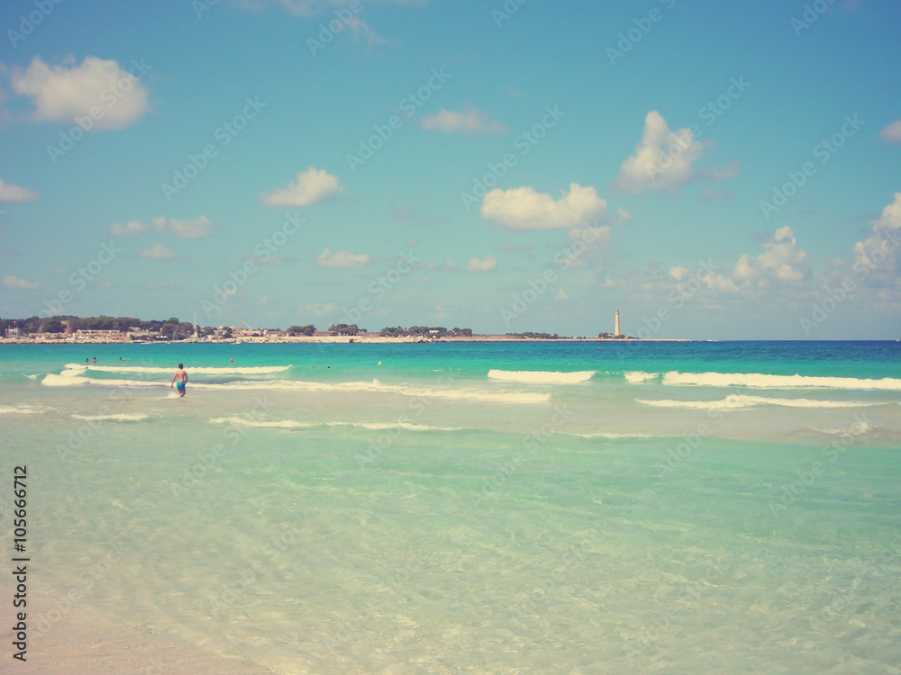 White sandy beach San Vito Lo Capo in Sicily, on a sunny summer day. Image filtered in faded, retro, Instagram style with extremely soft focus; nostalgic, vintage concept of summer travel.