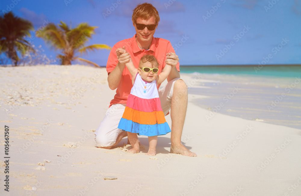 father and little daughter play on beach