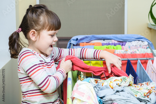 Girl hang stockings on the aluminum collapsible dryer and smilin photo