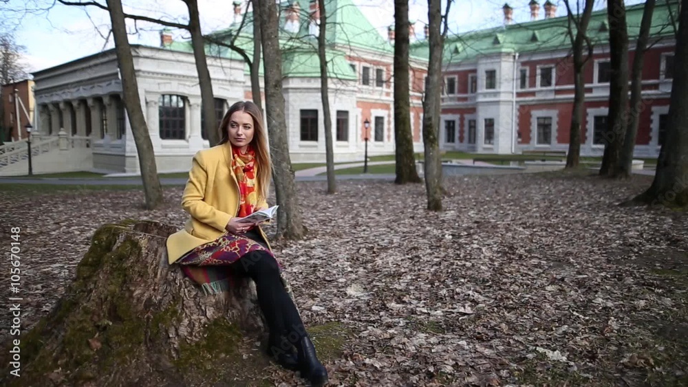 young girl sitting in an old castle park and reading a book in the spring young girl sitting in an old castle park and reading a book in the spring