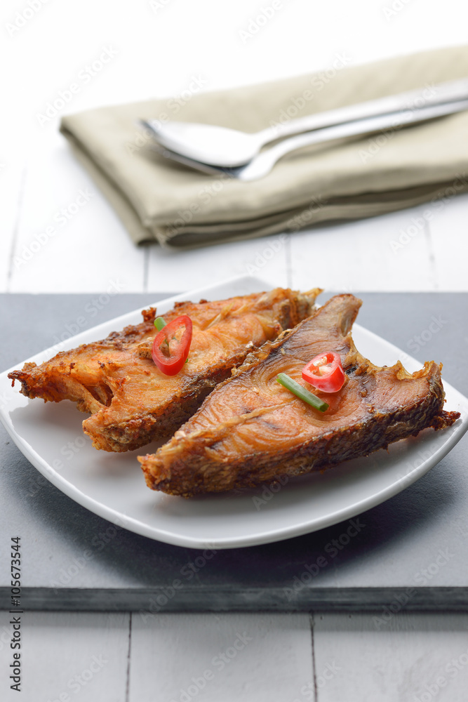Fried fish on plate on white plate Fried fish on plate on white plate