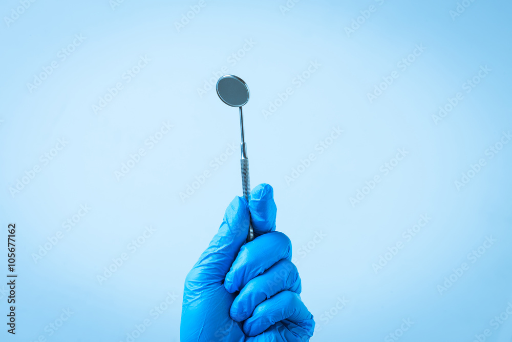 Gloved hand with dental instrument Gloved hand with dental instrument