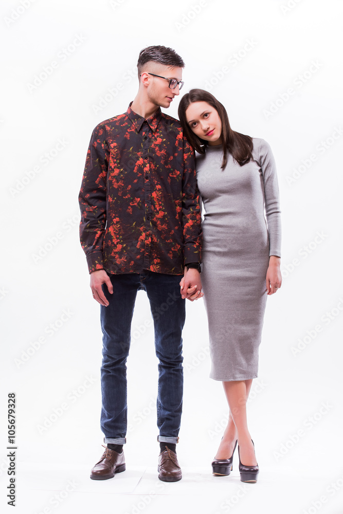 Happy hipster couple holding hands and look each other against white background Happy hipster couple holding hands and look each other against white background
